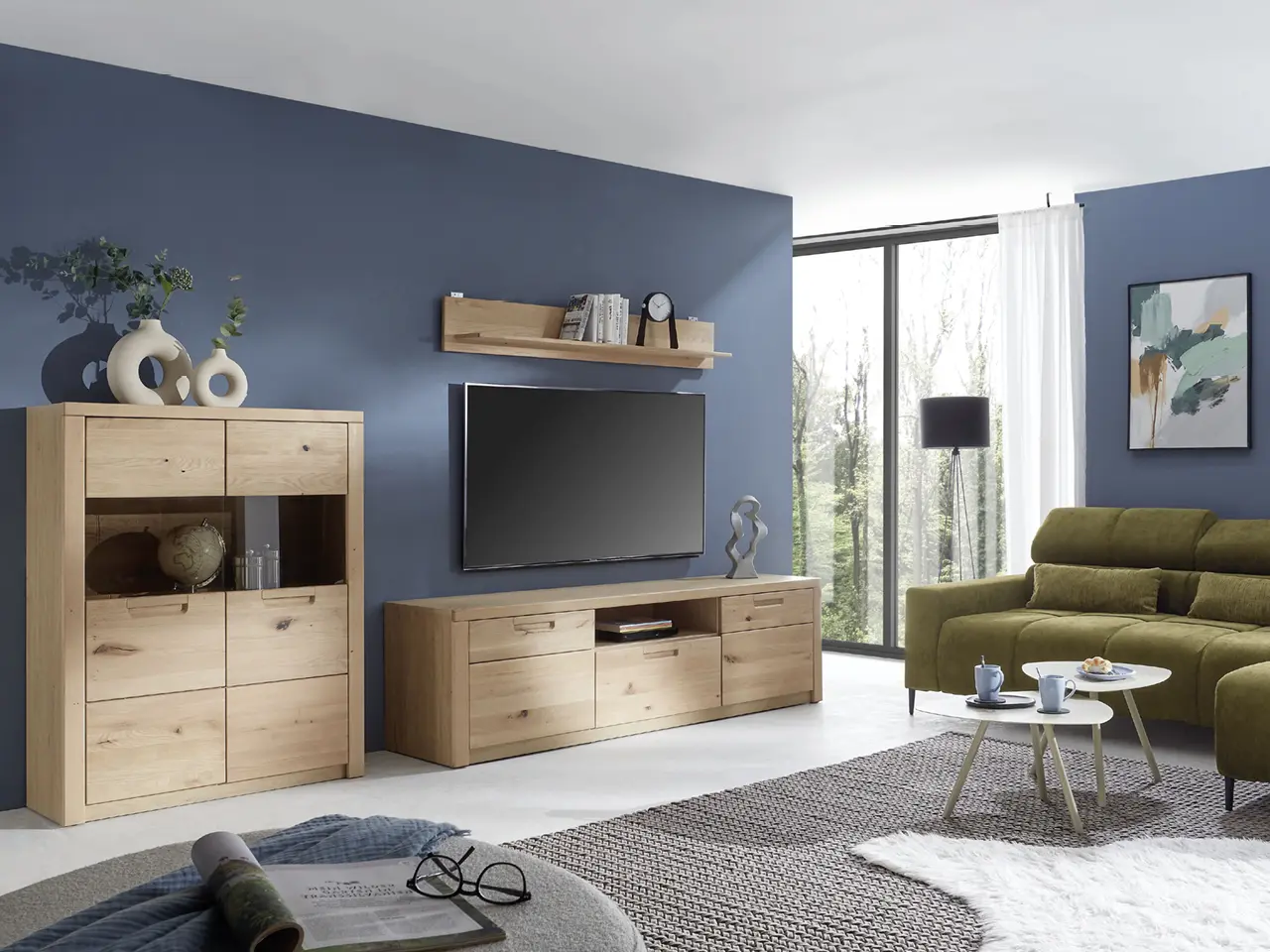 Wohnzimmer mit TV-Möbeln aus Holz, grünem Sofa, Teppich und großer Fensterfront